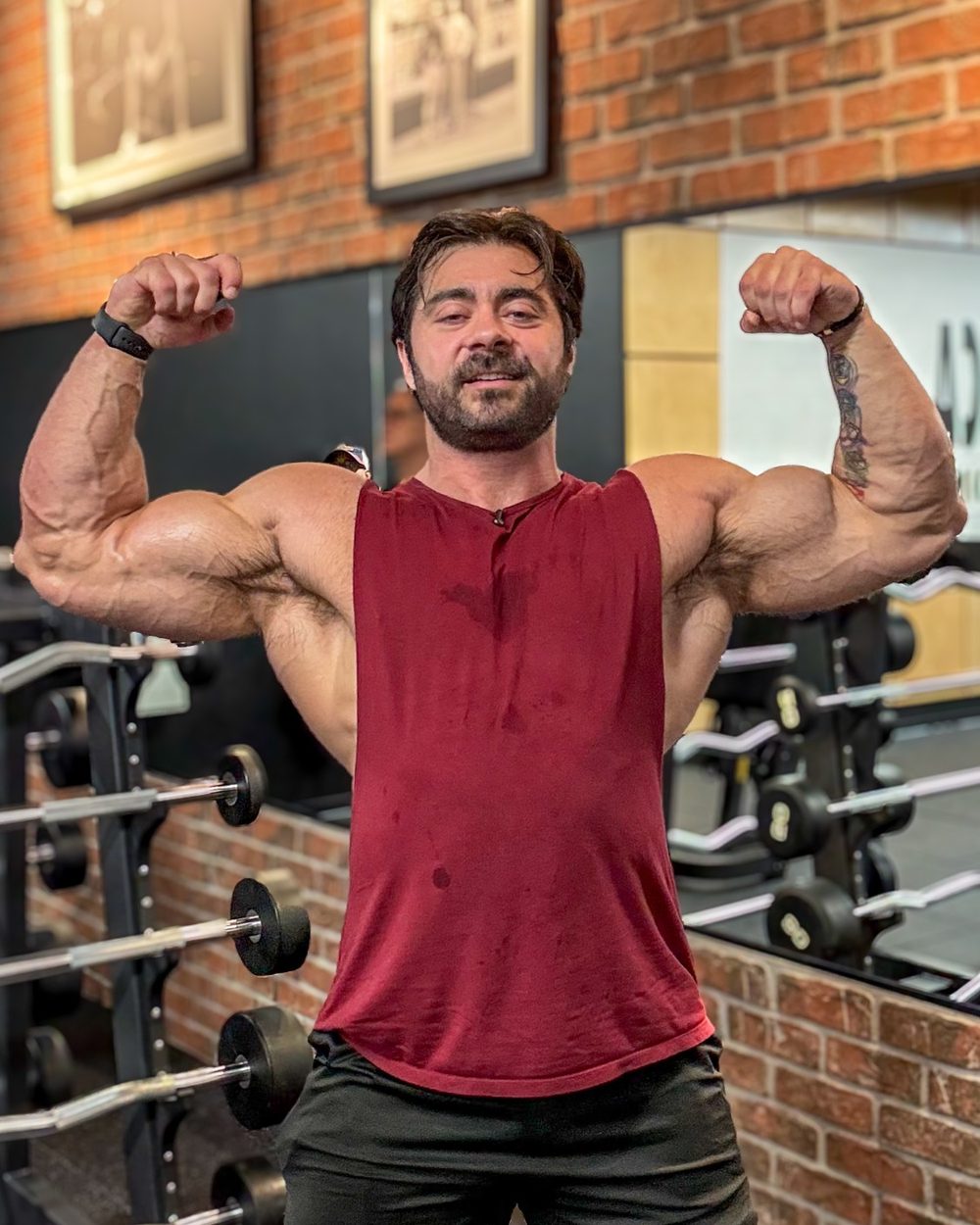 Derek Bolt hitting a double biceps pose in the gym